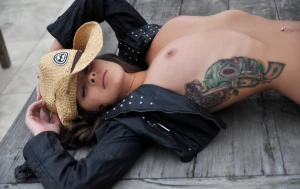 Tattooed girl in cowboy hat with nice perky tits out